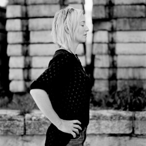 Cathy Davey standing from a side with hands on her sides with eyes closed.