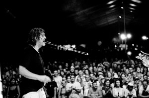 Emir Kusturica singing to the microphone on the stage at the concert of No Smoking Orchestra.
