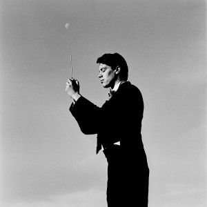Kevin Griffiths standing holding baton in his hands with the skies in the background and the moon.